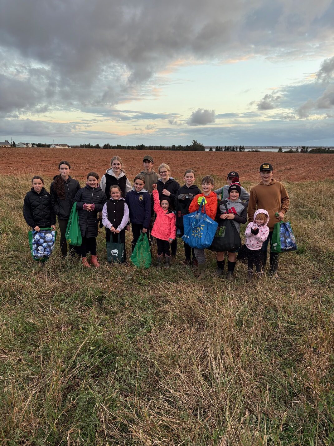 Kids in a field smile for a picture